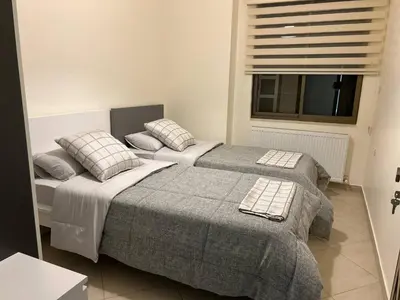 two beds in a bedroom with a window at 3 bedroom flat, 3 bathrooms, 7th circle, Amman in Amman
