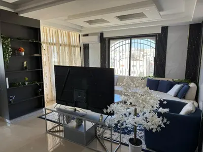 a living room with a blue couch and a tv at 2bedrooms sport city in Amman