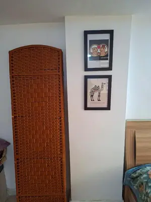 a bedroom with two pictures on a wall and a door at Mountain Pad Overlooking Jerash - HQ Budget stay in Jerash