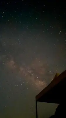 a night sky filled with stars and a building at Dawn Rum Luxury Camp in Wadi Rum