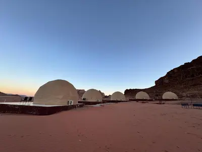 a group of domes in the desert on a beach at Dawn Rum Luxury Camp in Wadi Rum