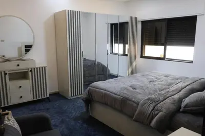 a bedroom with a bed and a mirror and a dresser at شقق الاستقلال in Amman