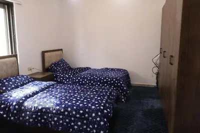 two beds sitting next to each other in a room at شقق الاستقلال in Amman