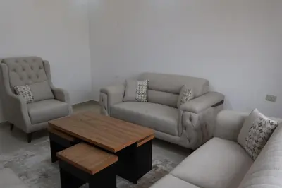 a living room with two couches and a coffee table at شقق الاستقلال in Amman