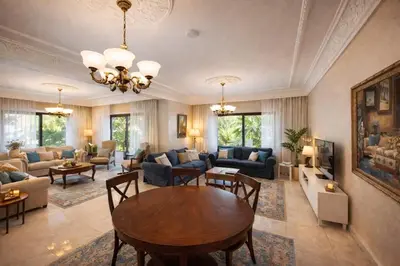 a living room with a table and a couch at Wadi Saqra Family Apartment in Amman