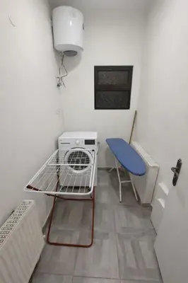 a small room with a table and a blue chair at Wadi Saqra Family Apartment in Amman
