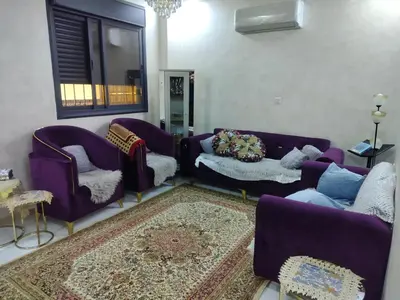 a living room with purple couches and a rug at شقق مفروشه فاخره2 in Aqaba