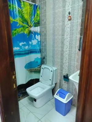 a bathroom with a toilet and a palm tree shower curtain at شقق مفروشه فاخره2 in Aqaba