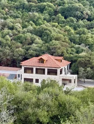 a house with a red roof on top of a mountain at Bait Ajloun in Khirbat Shīn