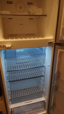 an empty refrigerator with its door open and its shelves at home 7 in Amman