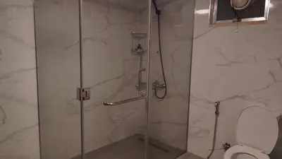 a bathroom with a glass shower with a toilet at home 7 in Amman