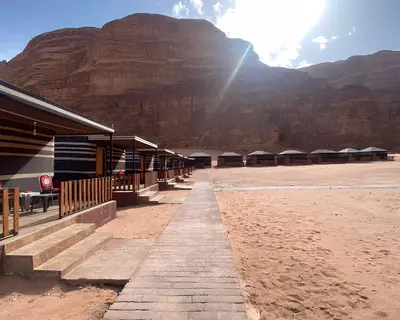 a building on the beach with a mountain in the background at Teraa rum luxury camp in Wadi Rum
