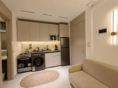 a kitchen with a washing machine and a couch in it at ذا سهل ستيز in Amman