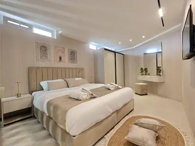 a bedroom with a large bed and a television at ذا سهل ستيز in Amman
