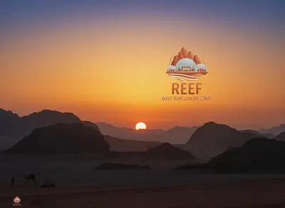a picture of a desert with the sun setting over the mountains at Reef Rum Luxury Camp in Disah