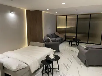 a bedroom with a bed and a couch and a table at Damac Towers TC1-517 in Amman