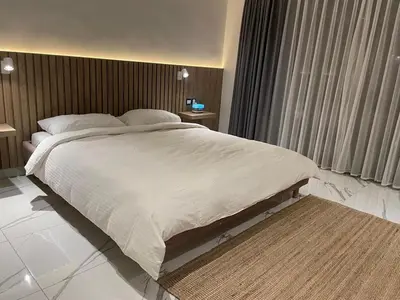 a bedroom with a large white bed with a window at Damac Towers TC1-517 in Amman