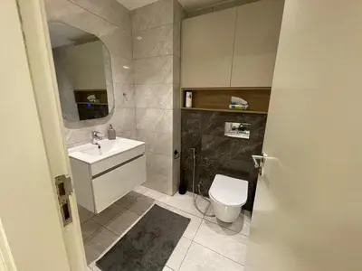 a bathroom with a white toilet and a sink at Damac Towers TC1-517 in Amman