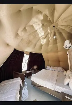 a bedroom with a large ceiling with two beds at Wadi rum Nader in Aqaba
