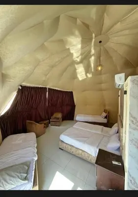 a bedroom with two beds and a ceiling at Wadi rum Nader in Aqaba