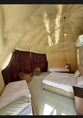 a bedroom with two beds in a room with a ceiling at Wadi rum Nader in Aqaba