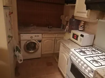 a kitchen with a stove and a washing machine at استديو للتأجير السنوي او البيع in Amman