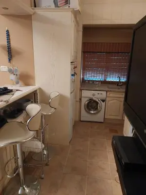 a kitchen with a table and chairs in a kitchen at استديو للتأجير السنوي او البيع in Amman