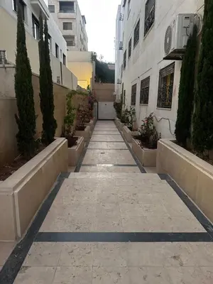 a walkway in a city with plants and buildings at شقة مميزة في عبدون -Special apartment in Abdon in Amman