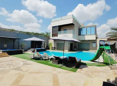 a house with a swimming pool with a slide at The Amazing View chalet in Al Rama