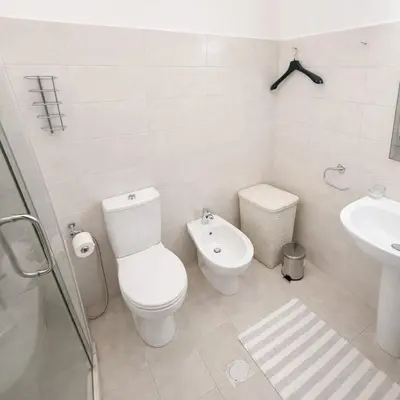 a white bathroom with a toilet and a sink at Abdoun Elite Residence Stunning View in Amman