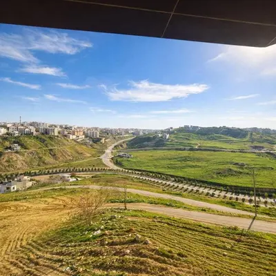 a view of a dirt road in a green field at Abdoun Elite Residence Stunning View in Amman