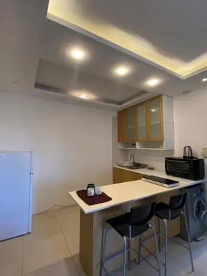 a kitchen with a counter with stools and a stove at Cozy Wabida in Amman