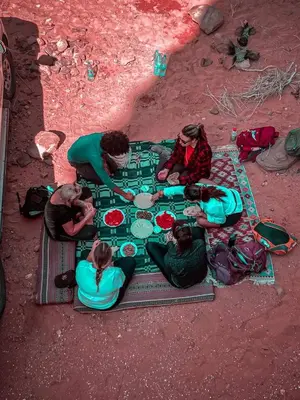 a group of people playing a board game on the ground at Desert Glow Wadi Rum in Wadi Rum