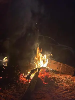 a fire with a car on top of it at night at Wadi Rum, Mars Cave in Wadi Rum