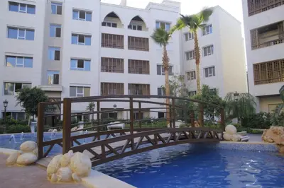 a bridge over a swimming pool in front of a building at saraya stays premium in Amman