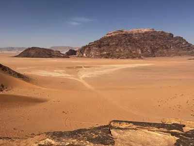 a desert with a large pyramid in the distance at Skylight Wadi Rum Camp in Disah