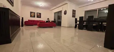 a living room with a red couch and a table at شقة مفروشة فاخرة in Amman