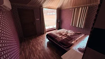 a bedroom with a bed in a room with a window at Silent Dunes Camp in Disah