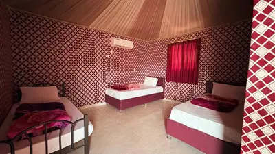 a room with two beds and a table in it at Silent Dunes Camp in Disah