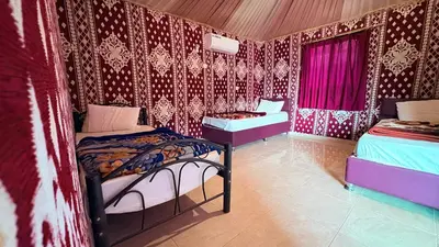 two beds in a room with red and white wallpaper at Silent Dunes Camp in Disah