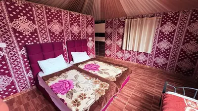 a bedroom with a purple bed and pink walls at Silent Dunes Camp in Disah