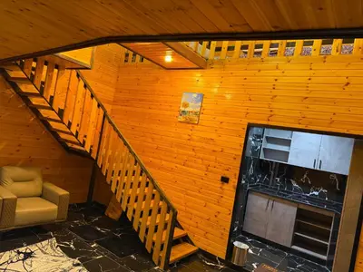 a room with a staircase and a chair in a house at Akwakh Al-Kanz اكواخ الكنز عجلون in Ajloun
