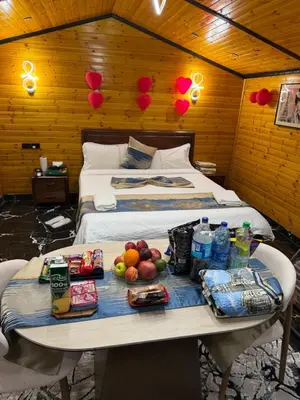 a room with a bed and a table with food on it at Akwakh Al-Kanz اكواخ الكنز عجلون in Ajloun