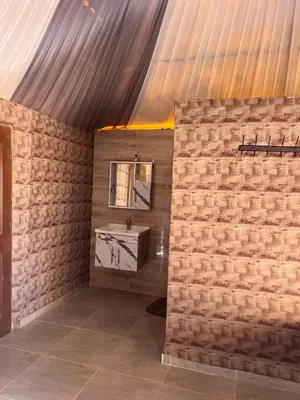a bathroom with a sink and a brick wall at Infinity Dunes Camp in Disah