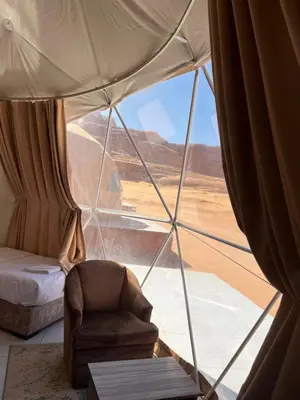 a room with a bed and a chair in a tent at Infinity Dunes Camp in Disah