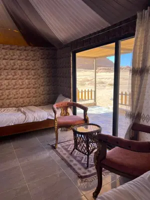 a room with a bed and a chair and a table at Infinity Dunes Camp in Disah