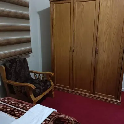 a bedroom with a chair and a wardrobe at Petra Eyes in Wadi Musa