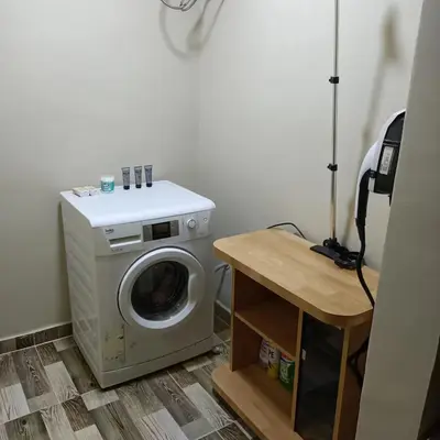 a washing machine in a room with a table at Petra Eyes in Wadi Musa