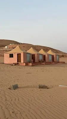 a row of houses in the desert with a sand field at Wadi rum camp in Wadi Rum