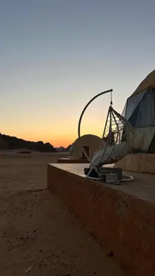 a tent in the desert with the sunset in the background at Wadi rum camp in Wadi Rum